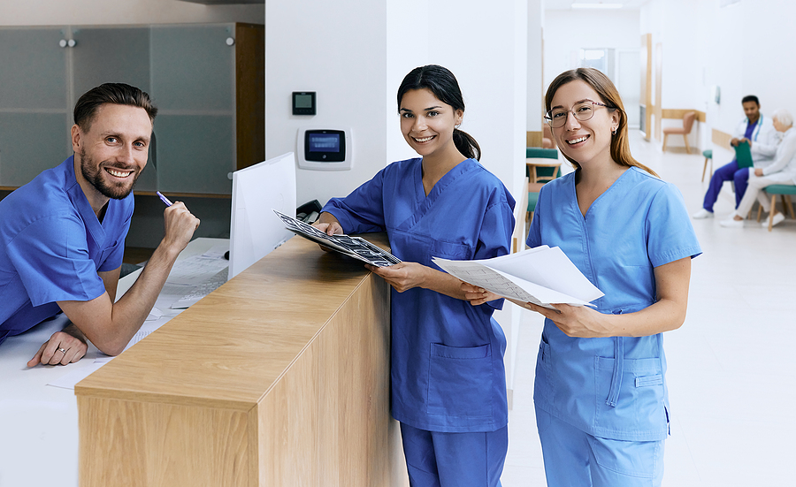 Medical staff standing at a nurses station in a hospital.